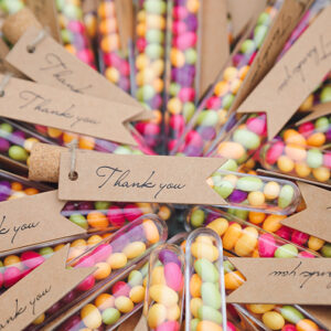 Vials of jelly beans party favors with "thank you" tag attached